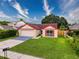 Inviting single-Gathering home with a manicured lawn, a two-car garage, and vibrant red window shutters at 5016 Cypress Trace Dr, Tampa, FL 33624
