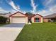 Attractive single-story home boasting a well-kept lawn, two-car garage, and red-trimmed windows and roof at 5016 Cypress Trace Dr, Tampa, FL 33624