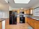 Well-equipped kitchen features wood cabinets, black appliances, and easy access at 5016 Cypress Trace Dr, Tampa, FL 33624