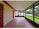 Enclosed patio with tile flooring leading to the backyard, featuring a red door at 5016 Cypress Trace Dr, Tampa, FL 33624