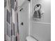 Close-up of a clean white tiled shower with bronze fixtures and a patterned shower curtain at 5053 18Th St, Zephyrhills, FL 33542