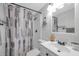 Bright bathroom with a shower and tub combination, complemented by a stylish gray and beige shower curtain at 5053 18Th St, Zephyrhills, FL 33542