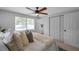 A bedroom with a ceiling fan, natural light, and closet space at 5053 18Th St, Zephyrhills, FL 33542