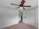 Neutral bedroom with a ceiling fan, carpet, a closet, and a doorway to another room at 5053 18Th St, Zephyrhills, FL 33542