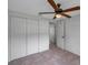 Neutral bedroom with a ceiling fan, tile floors, closet, and door to another room at 5053 18Th St, Zephyrhills, FL 33542