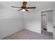 Neutral bedroom with a ceiling fan, neutral carpet, and attached bathroom at 5053 18Th St, Zephyrhills, FL 33542