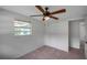 Neutral bedroom with a ceiling fan, tile floors, closet, and window at 5053 18Th St, Zephyrhills, FL 33542
