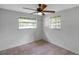Neutral bedroom with a ceiling fan, tile floors, and a pair of windows at 5053 18Th St, Zephyrhills, FL 33542