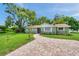 View of a single-story home featuring a brick walkway and mature, green landscaping at 5053 18Th St, Zephyrhills, FL 33542