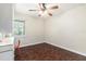 Cozy bedroom featuring hardwood floors, a ceiling fan, and natural light from a window at 5106 Five Acre Rd, Plant City, FL 33565