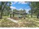 Rear view of charming single-story home featuring stone accents, covered porch and metal roof at 5106 Five Acre Rd, Plant City, FL 33565