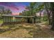 Charming single-story home featuring stone accents and a metal roof under a colorful twilight sky at 5106 Five Acre Rd, Plant City, FL 33565