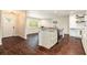 Well-lit kitchen featuring an island with stone countertops, white cabinets, and stainless steel appliances at 5106 Five Acre Rd, Plant City, FL 33565