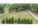 Expansive lot with verdant lawn, bordered by a charming wooden fence and mature trees, offering privacy at 5106 Five Acre Rd, Plant City, FL 33565
