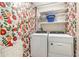 Charming laundry room with floral wallpaper, shelving, and modern appliances at 5106 Five Acre Rd, Plant City, FL 33565
