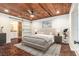 Relax in this main bedroom featuring wood ceiling, barn door to ensuite bathroom, and modern decor at 5106 Five Acre Rd, Plant City, FL 33565