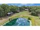 Reflective pond offering peaceful views with surrounding greenery and multiple buildings on the property at 5106 Five Acre Rd, Plant City, FL 33565