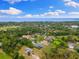 Aerial view of a home in a wooded neighborhood with a glimpse of the bay in the distance at 512 Creekside Ct, Safety Harbor, FL 34695