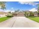 Stately home featuring a three-car garage, well-manicured lawn, and inviting driveway at 512 Creekside Ct, Safety Harbor, FL 34695