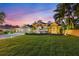 Beautiful home with a long driveway and lush landscaping, illuminated by landscape lighting at twilight at 512 Creekside Ct, Safety Harbor, FL 34695