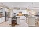 The kitchen has white cabinets, stainless steel appliances and a granite countertop island with seating at 512 Creekside Ct, Safety Harbor, FL 34695