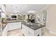 Open kitchen features white cabinets, granite counters, and a center island with bar seating and open dining area at 512 Creekside Ct, Safety Harbor, FL 34695