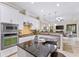 Well-lit kitchen with stainless steel appliances, modern cabinetry, and island with seating flows into an open space at 512 Creekside Ct, Safety Harbor, FL 34695
