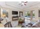 Comfortable living room featuring a leather sofa, mounted TV and a view of the sparkling pool through sliding doors at 512 Creekside Ct, Safety Harbor, FL 34695