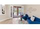 Bright living room with blue couches opens to a screened pool area for seamless indoor-outdoor living at 512 Creekside Ct, Safety Harbor, FL 34695