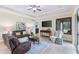 Cozy living room with leather sofa, soft rug, tray ceiling, and media center for relaxing or entertaining at 512 Creekside Ct, Safety Harbor, FL 34695