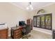 This home office features a wood desk, tile flooring, and a window with plantation shutters at 512 Creekside Ct, Safety Harbor, FL 34695
