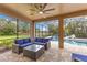 Inviting screened patio with stylish blue furniture, perfect for relaxing and entertaining by the pool at 512 Creekside Ct, Safety Harbor, FL 34695