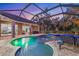 Lush screened pool with color LED lights, tropical landscaping, and seamless indoor-outdoor living at 512 Creekside Ct, Safety Harbor, FL 34695
