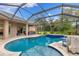 Beautiful pool with a waterfall feature, surrounded by a spacious screened-in patio, perfect for relaxation at 512 Creekside Ct, Safety Harbor, FL 34695