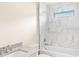 Sleek bathroom features a single vanity and a shower-tub with elegant marble tiling at 5441 Chestnut Ridge Rd, Dade City, FL 33523