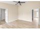 Light and airy bedroom with wood look flooring, ceiling fan, and two doors at 5441 Chestnut Ridge Rd, Dade City, FL 33523