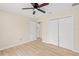 Bedroom boasts wood-look floors, ceiling fan, and closet for ample storage at 5441 Chestnut Ridge Rd, Dade City, FL 33523