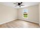 Bright bedroom with light wood floors, ceiling fan, and natural light from a large window at 5441 Chestnut Ridge Rd, Dade City, FL 33523