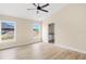 Bright bedroom features wood-look floors, ceiling fan, and two windows for natural light at 5441 Chestnut Ridge Rd, Dade City, FL 33523