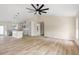 Open-concept living room features wood-look floors with the kitchen adjacent and natural light at 5441 Chestnut Ridge Rd, Dade City, FL 33523