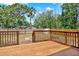 Spacious wooden back deck overlooking the fenced in yard and mature trees on a sunny day at 6220 Pershing Ne St, St Petersburg, FL 33702