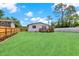 A sprawling green backyard with a small deck and privacy fence offers space to play at 6220 Pershing Ne St, St Petersburg, FL 33702