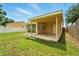 Backyard showcasing a covered patio and a fully fenced yard, ideal for outdoor activities at 6941 58Th N Way, Pinellas Park, FL 33781