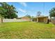 Fenced backyard showcasing a well-manicured lawn and mature trees, offering a private retreat at 6941 58Th N Way, Pinellas Park, FL 33781