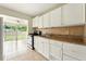 Bright kitchen featuring granite counters, white cabinets, tile flooring, and view to the sunroom and backyard at 6941 58Th N Way, Pinellas Park, FL 33781