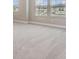 Bright carpeted bedroom with two windows offering ample natural light and exterior views at 7276 Notched Pine Bnd, Wesley Chapel, FL 33545