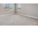 Bright carpeted bedroom with two windows offering ample natural light and exterior views at 7276 Notched Pine Bnd, Wesley Chapel, FL 33545
