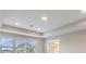 Tray ceiling bedroom with large windows and bathroom access at 7276 Notched Pine Bnd, Wesley Chapel, FL 33545