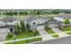 Aerial view of a home with landscaped lawn, paver driveway and stone accents in a residential neighborhood at 7276 Notched Pine Bnd, Wesley Chapel, FL 33545