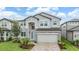 Beautiful two-story home with stone accents, manicured landscaping, and a paver driveway at 7276 Notched Pine Bnd, Wesley Chapel, FL 33545